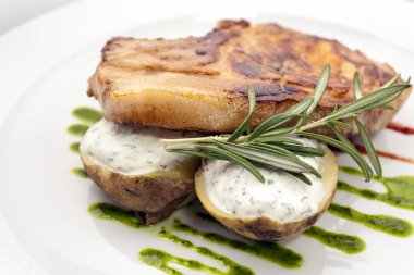 beyaz bir tabak tabaktabaktabaktabak tabaktabaktabak tabaktabaktabak tabaktabaktabaktabak tabaktabaklarında kremalı sos, biberiye ve kivi sosu ile doldurulmuş patates ile domuz pirzolası sulu parça