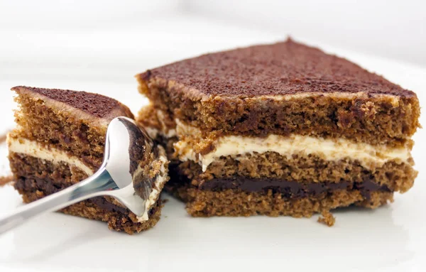 빛나는 숟가락으로 나누어 맛있는 초콜릿 케이크의 배경에 클로즈업 — 스톡 사진