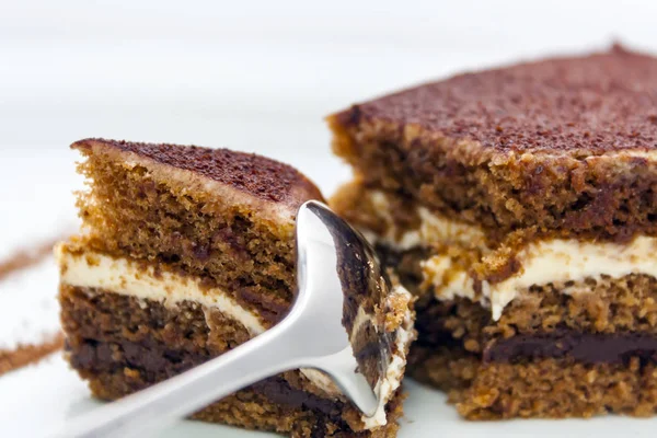 빛나는 숟가락으로 나누어 맛있는 초콜릿 케이크의 배경에 클로즈업 — 스톡 사진