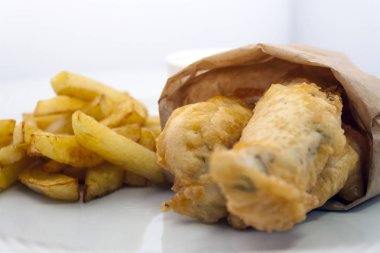 beyaz bir tabak izole üzerinde tartar soslu geleneksel İngiliz balık ve cips