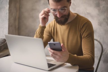 kafede dizüstü bilgisayarda çalışan gözlük yakışıklı sakallı adam