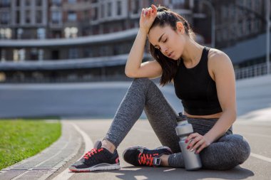 genç güzel koyu saçlı atletik kız spor dışarı asılı, ısınma ve onun sağlığı için spor egzersizleri ve şehir sokak bisiklet pistinde bir koşu bandı üzerinde güçlü bir sağlıklı vücut performans