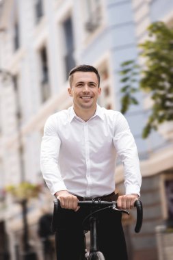 şehirde bisiklet sürme gömlek yakışıklı adam