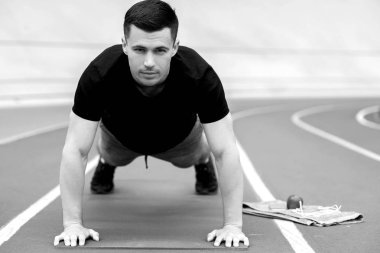 yakışıklı sporcu stadyumda push up yapıyor 