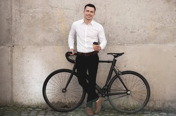 Красивый Мужчина Стоящий Велосипедом Кофе Бумажной Чашке Возле Стены Улице — стоковое фото