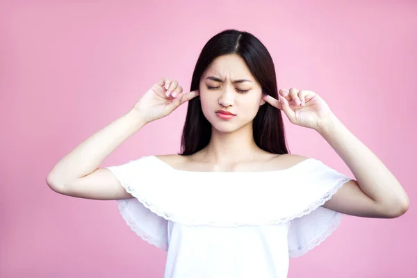 ピンクの背景に耳を覆う魅力的なアジアの女の子 — ストック写真
