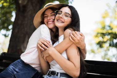 Mutlu brightful şehir sokakta sarılma iki şık kız olumlu anları. Eğleniyor portre portre komik neşeli attarctive genç kadın, gülümseyen, güzel anlar, en yakın arkadaşlarım