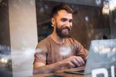 Yetenekli adam programcı bu arada kayıt tutmak için dizüstü bilgisayar ve bir dizüstü bilgisayar kullanır uygulama yazılımı geliştirir. Yakışıklı olgun işadamı net kitap kullanarak e-posta gönderiyor. Yeni İnternet