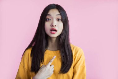pembe arka plan üzerinde kendini işaret sarı kazak şok asyalı kız