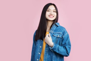 pembe arka plan üzerinde poz gülümseyen asyalı kız