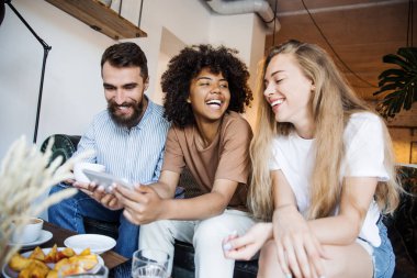 Ağaç genç öğrenciler arkadaşlar kahve molası cep telefonu ve gülüyor arıyorum