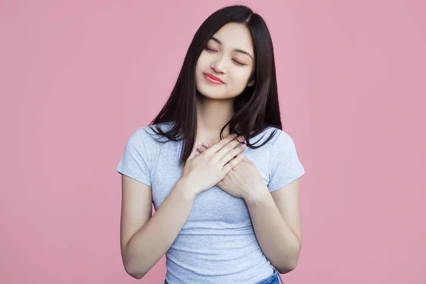 Sorrindo Menina Asiática Com Mãos Peito Fundo Rosa — Fotografia de Stock