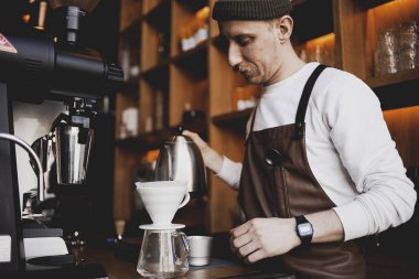 Man Barista bir damla demleme yapmak, filtre kahve, ya da dökme-over kavrulmuş üzerine su dökme içeren bir yöntemdir, bir filtre bulunan öğütülmüş kahve çekirdekleri. Bir kafede. Vintage tonu