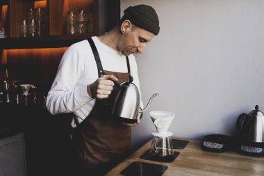 Man Barista bir damla demleme yapmak, filtre kahve, ya da dökme-over kavrulmuş üzerine su dökme içeren bir yöntemdir, bir filtre bulunan öğütülmüş kahve çekirdekleri. Bir kafede. Vintage tonu