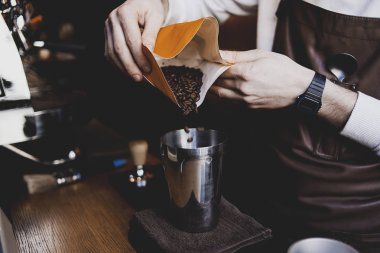 Yerel kahve dükkanında aroma kahve çekirdekleri. Barista müşteriiçin kahve içiyor. Kendi alanında profesyonel ve bilgi adamı. Kahve hazırlama nın ilginç süreci