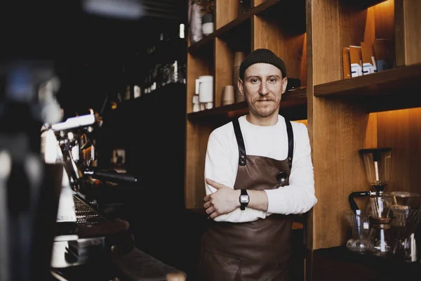 Portrait of bearded happy barista standing at trendy coffee shop, cafe - small business concept. Hipster barista man with beard. Own business, modern businessman