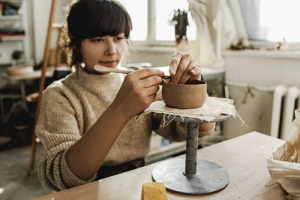 プロの女性の女性ポッターは 新しい手作りの彫刻粘土料理やインテリアのための何かを作成し モデリングするプロセスで彼女の創造的なアートスタジオで 創造的な職業 アートスペース — ストック写真
