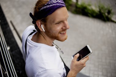 Yeni modern gadget telefon, cep, moda yakışıklı hipster adam elinde serin yeni uygulamalar ile akıllı telefon, kim ofisinin yakınında yürüyüş ve bazı iyi haber söylemek için birine çağrı. 