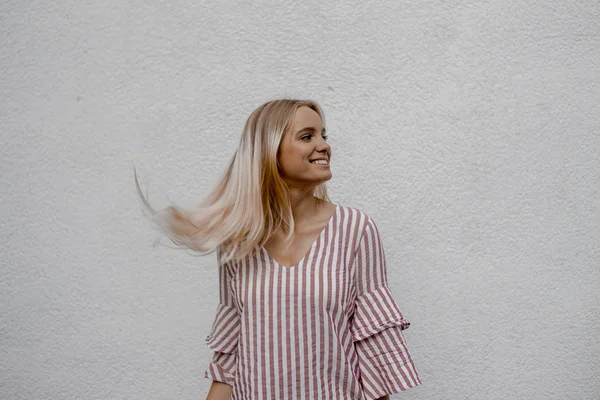 Усміхнена Приваблива Блондинка Дивиться Далеко Біля Сірої Стіни Вулиці — стокове фото