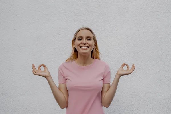 Sorrindo Mulher Loira Atraente Mostrando Gesto Mudra Perto Parede Cinza — Fotografia de Stock