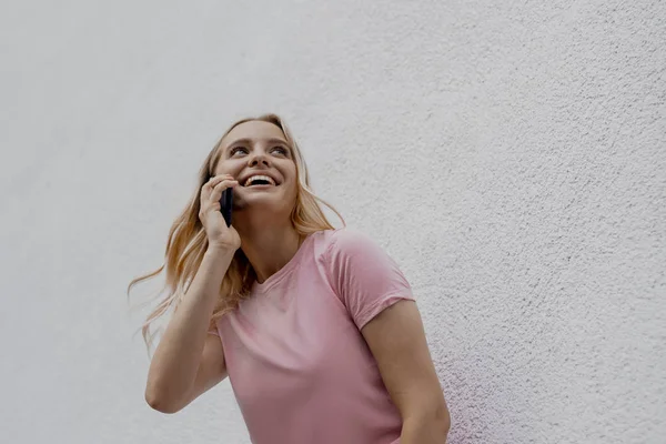 Sorrindo Mulher Loira Atraente Falando Por Smartphone Perto Parede Cinza — Fotografia de Stock