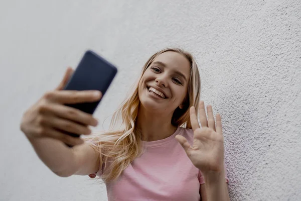 Sorrindo Atraente Mulher Loira Tomando Selfie Com Smartphone Perto Parede — Fotografia de Stock