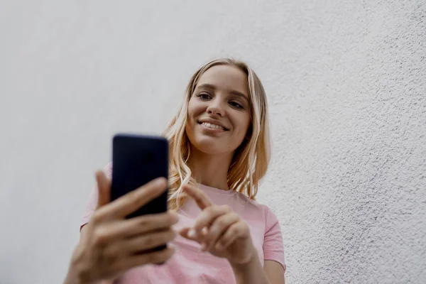 Baixo Ângulo Vista Sorrir Mulher Loira Atraente Usando Smartphone Perto — Fotografia de Stock