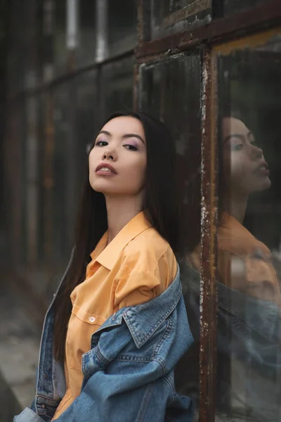 Young Asian woman waiting someone who late and looking out behin