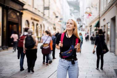Şuraya bak! Etkilenmiş bir kadın turist ilk uçuştan sonra yeni bir ülkede yeni bir şehirde yürür. Bu onun yeni bir tur operatörüyle ilk turu. Şehrin manzaraları na hayran. 