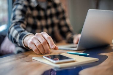 Sokak kentsel kafe dükkanımodern iç akıllı telefon kullanarak erkek el yakın çekim görüntü, arama veya sosyal ağlar kavramı, hipster adam arkadaşlarına bir sms mesajı yazarak