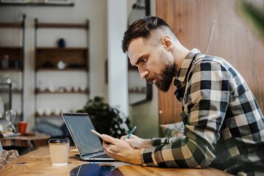 Bir süreç üzerinde konsantrasyon. Akıllı erkek metin yazarı yan görünümü netbook oturan web sayfası için yayın hazırlama uzak iş üzerinde yoğunlaşmıştır. Tasarımcı dizüstü bilgisayar becerilerini geliştirmek için web semineri izlerken