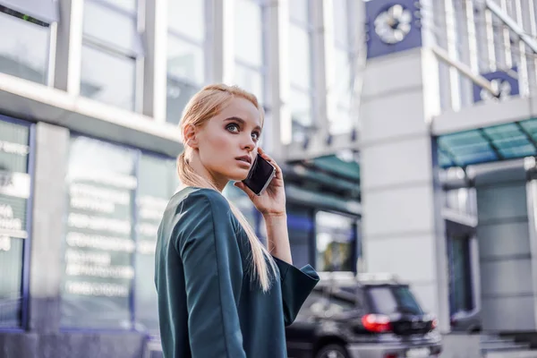 Successful professional woman calling cell phone with serious concentration face. Working process in progress. Fashionable modern style. Business office lifestyle