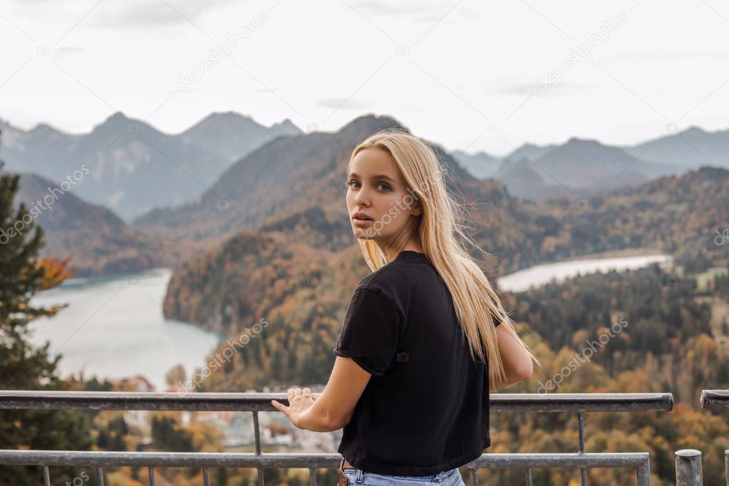 Looking back, beautiful woman thinking about dreams, fantastic mountains background. True traveler hiking mountains alone. Calm mood, nature, mountain lake. Journey on holidays, trendy, lifestyle 