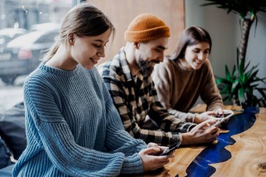 Ofiste ki bir bilgisayarda çalışan sıradan iş ekibi. Ofiste çalışma süreci. Gençler modern ofiste ortakları ile konuşma yapıyor. Bulanık arka plan. Kırpılmış, yakın çekim 