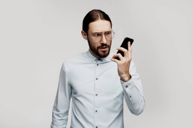 Stres her gün rutin. Çığlık atan öfkeli iş adamı gözlükleri meraklı yüzü ile onun cep telefonu akıllı telefon bakarak. Sorunlar ve internet bağlantısı ile ilgili sorunlar. Dijital teknoloji.