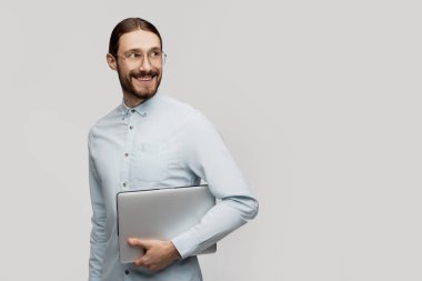 Kendine güvenen iş uzmanı. Gömlek ve kravat dizüstü tutarak ve beyaz arka plan karşı dururken gülümseyen kendine güvenen genç yakışıklı adam