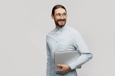 Yakışıklı gazeteci haber programcısı düşünüyor, internet arama ve kablosuz bağlantı için bilgisayar tutar, özenli bakışları vardır, şeffaf gözlük ve rahat giysiler giyer, beyaz izole