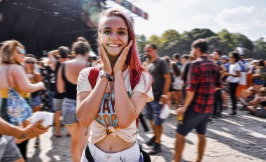 True emotions of a young hipster woman with pink hair at a world-wide music festival. At a concert of your favorite artist. Many people in the scene dance and sing along, happy moments of life clipart