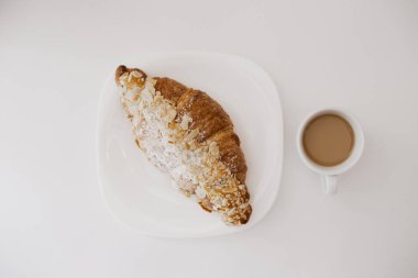 Taze fransız geleneksel kruvasan fırında ve beyaz fincan sütlü kahve espresso ile sabah tatlı lezzetli kahvaltı. Kopyalama alanı ile beyaz stüdyo arka plan. Kafe veya restoran menüsü için resim.