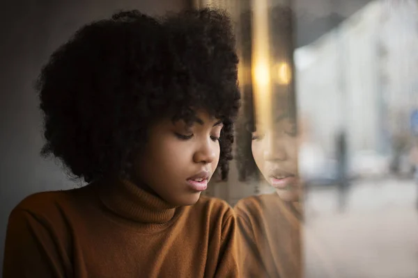 Una Joven Apariencia Afroamericana Sienta Una Mesa Ella Tiene Una —  Fotos de Stock