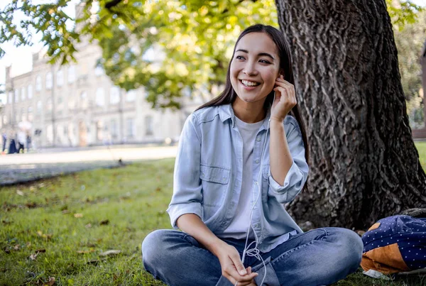 Mládež Krásná Studentka Která Sedí Parku Zelené Trávě Naslouchá Hudbě — Stock fotografie