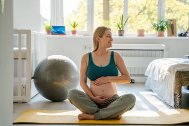 Hamile fitness eğitmeni evde spor yapıyor annelik ve doğum için hazırlanıyor, hamile kadınlar için doğum, spor ve yoga hazırlıyor.