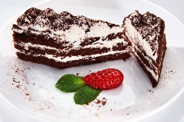 Шоколадний торт на білій тарілці з полуницею та м'ятою — стокове фото