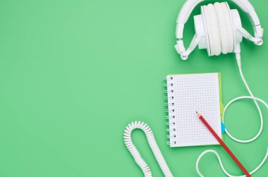 genç bir çocuğun masanın üst görünümü, kompozisyon kulaklıklar açık yeşil arka plan üzerinde dizüstü kalem