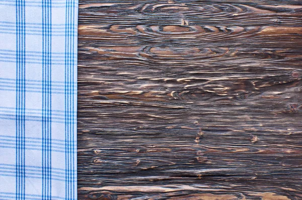 Old dark wooden background. Wooden table with blue kitchen towels