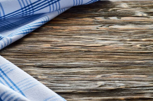 Old dark wooden background. Wooden table with blue kitchen towels