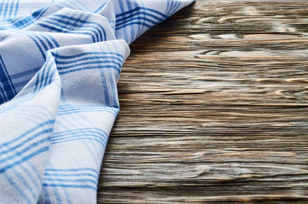 Old dark wooden background. Wooden table with blue kitchen towels