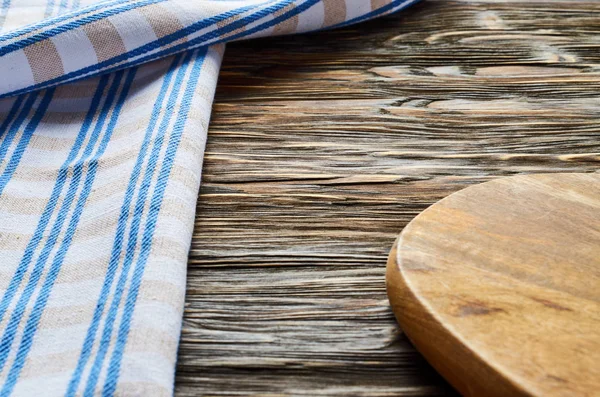 Old dark wooden background. Wooden table with blue kitchen towels