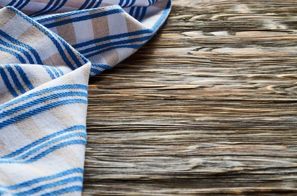 Old dark wooden background. Wooden table with blue kitchen towels