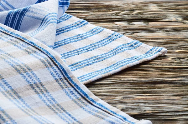 Old dark wooden background. Wooden table with blue and white kitchen towel — Stock Photo, Image